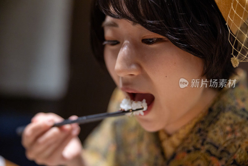 身穿和服/袴服的年轻女子在日本餐厅吃午餐的特写